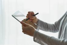 Person writing on tablet